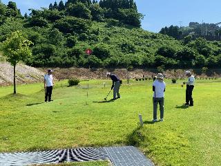 6と書かれたフラッグの周囲でパークゴルフをしている人々