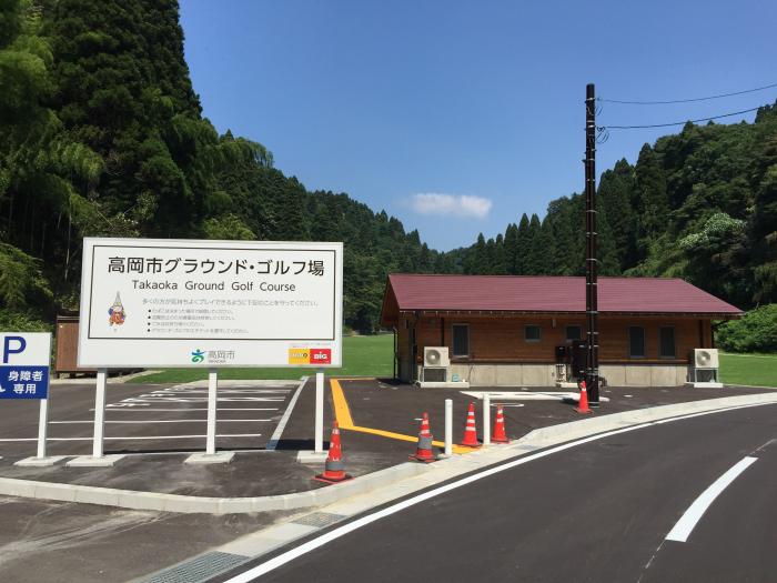 駐車場に設置されている白い看板と建物が並んでいる写真