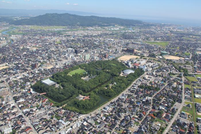 南側より俯瞰で撮影された、高岡市市街地および高岡城跡の空中写真