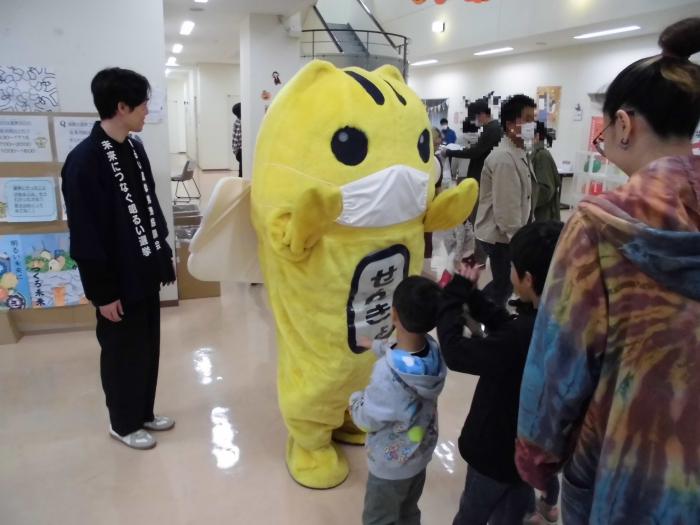 選挙啓発ポスターの手前にいるめいすいくんと子供たちの写真