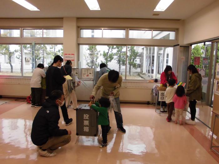 模擬投票を体験する来訪者たちの写真