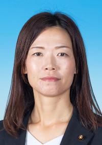 黒いスーツを着て髪を下ろした女性の写真