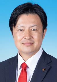 黒のスーツに赤色のネクタイを着けた男性の写真