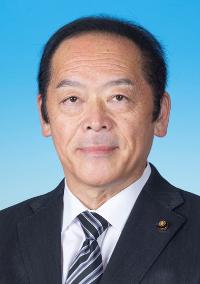 黒のスーツに白い線の入った黒色のネクタイを着けた男性の写真