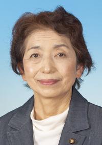 暗い灰色のスーツを着た茶髪の女性の写真