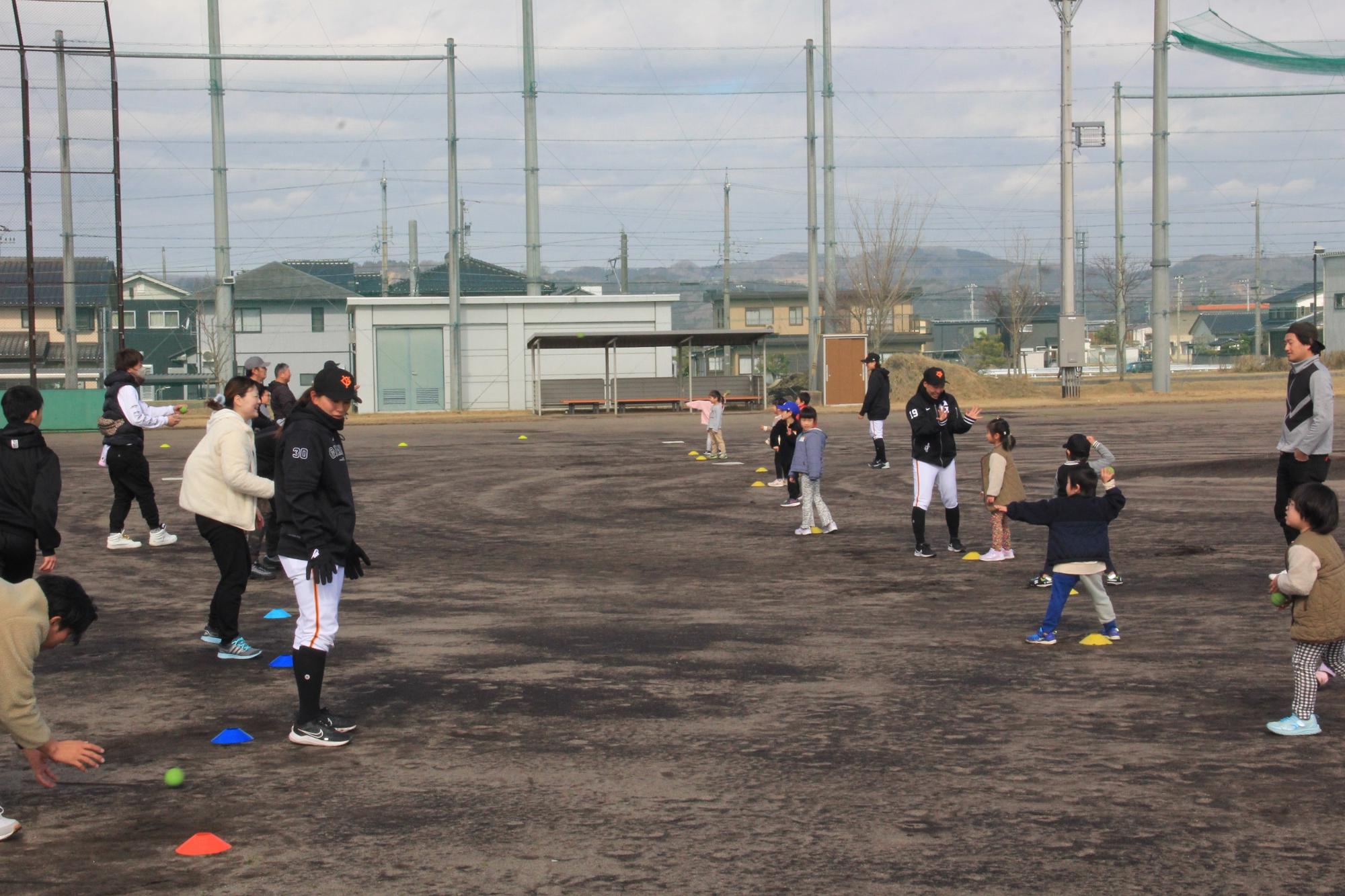 子どもに投げ方を指導する読売ジャイアンツ女子選手の様子