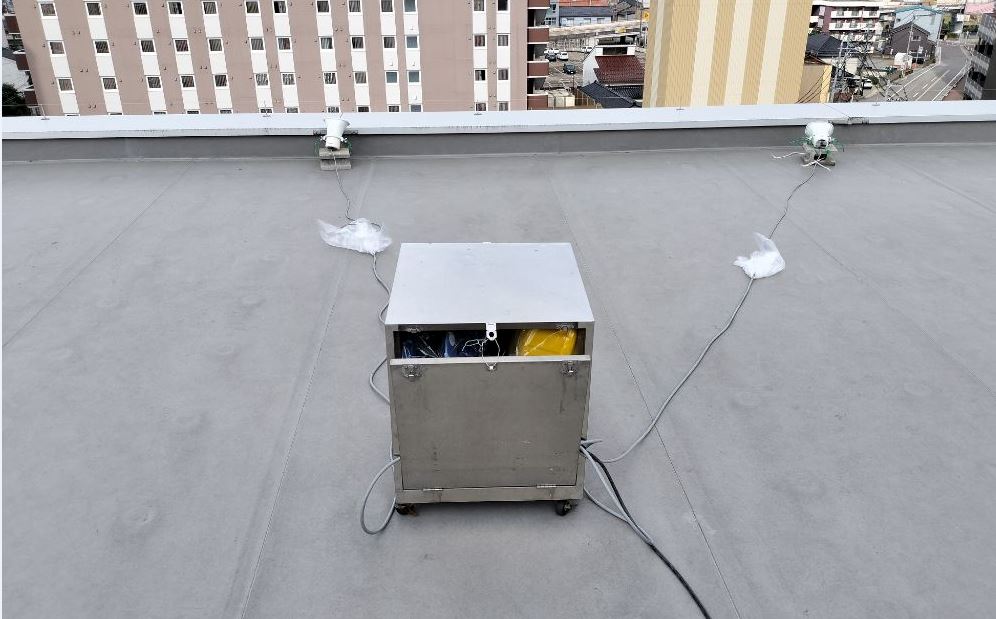 建物屋上に設置された、音声装置のスピーカーの写真