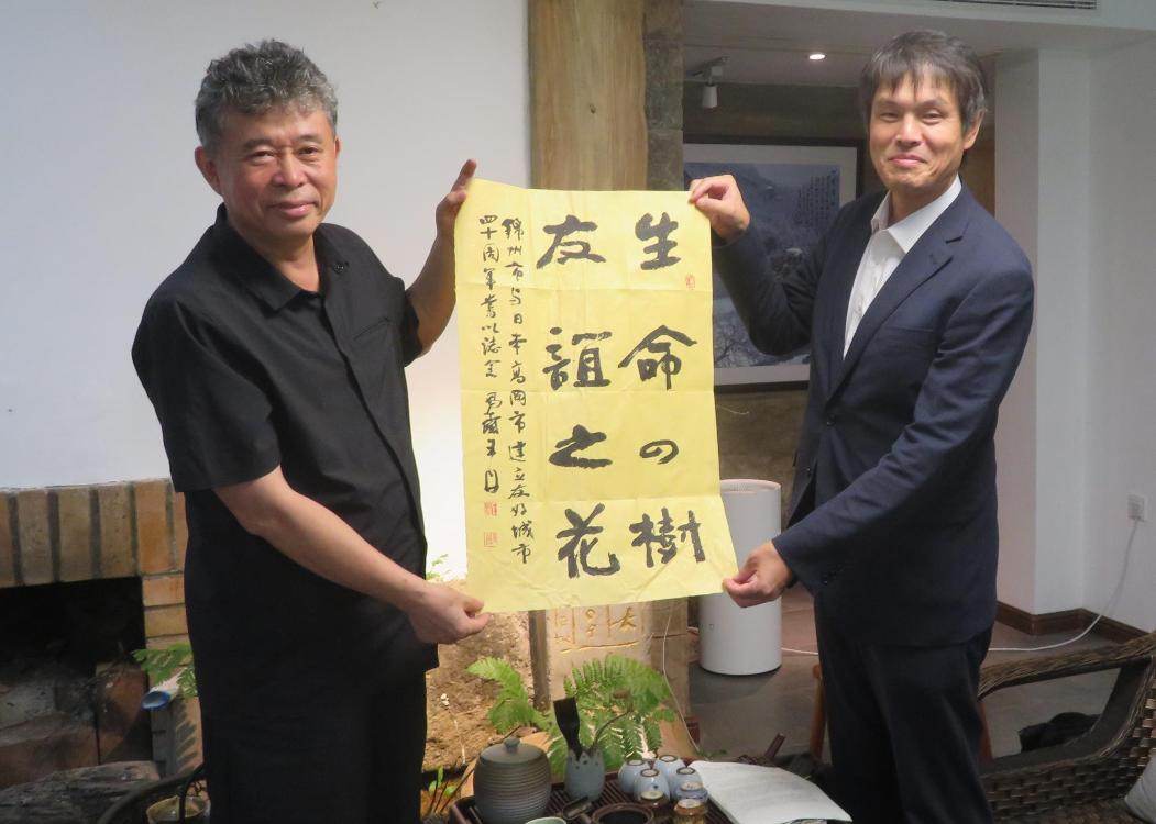 中国書道家協会副会長の王丹氏と高岡市日中友好協会会長が友好提携40周年を記念する書を手交
