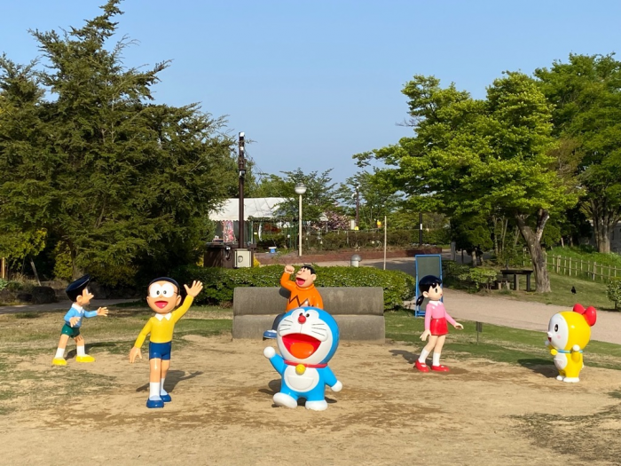 スペース内に土管とドラえもんの主要キャラクターたちの立像が設けられた、「ドラえもんの空き地」の風景写真