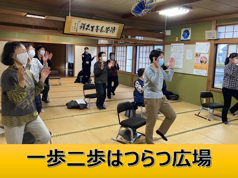 一歩二歩はつらつ広場と書かれたタイトル書きと、畳張りの部屋で複数の人々が椅子から立ち上がり、片足立ちし、両手を叩いている様子の写真