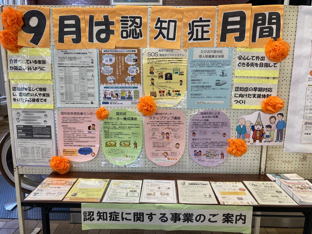 「9月は認知症月間」と装飾された展示板があり、その手前に関連する資料が並べられている様子の写真
