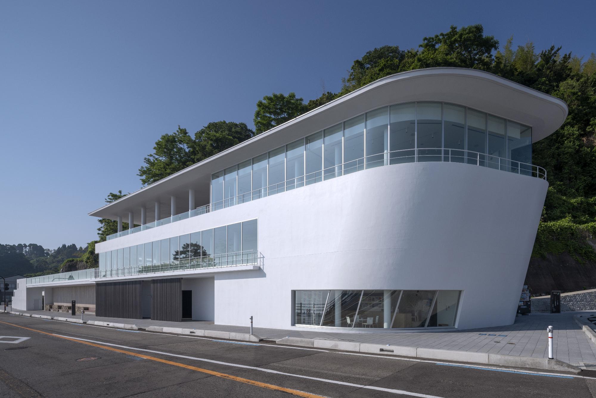 日本海側より撮影された、義経岩と道の駅「雨晴」の建物の遠景写真