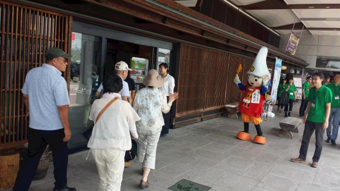 マスコットキャラクターとイベントスタッフが屋外にて活動している様子の写真