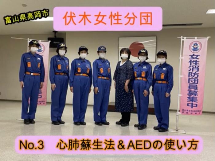 制服を着た女性7人が「女性消防団員募集中」というのぼりとともに横に並んでいる様子の写真