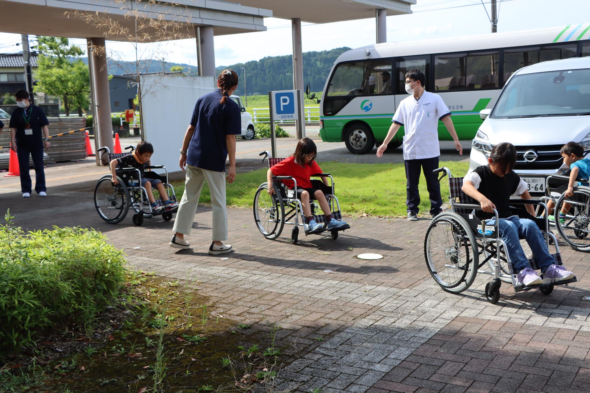 車椅子体験をする児童たち