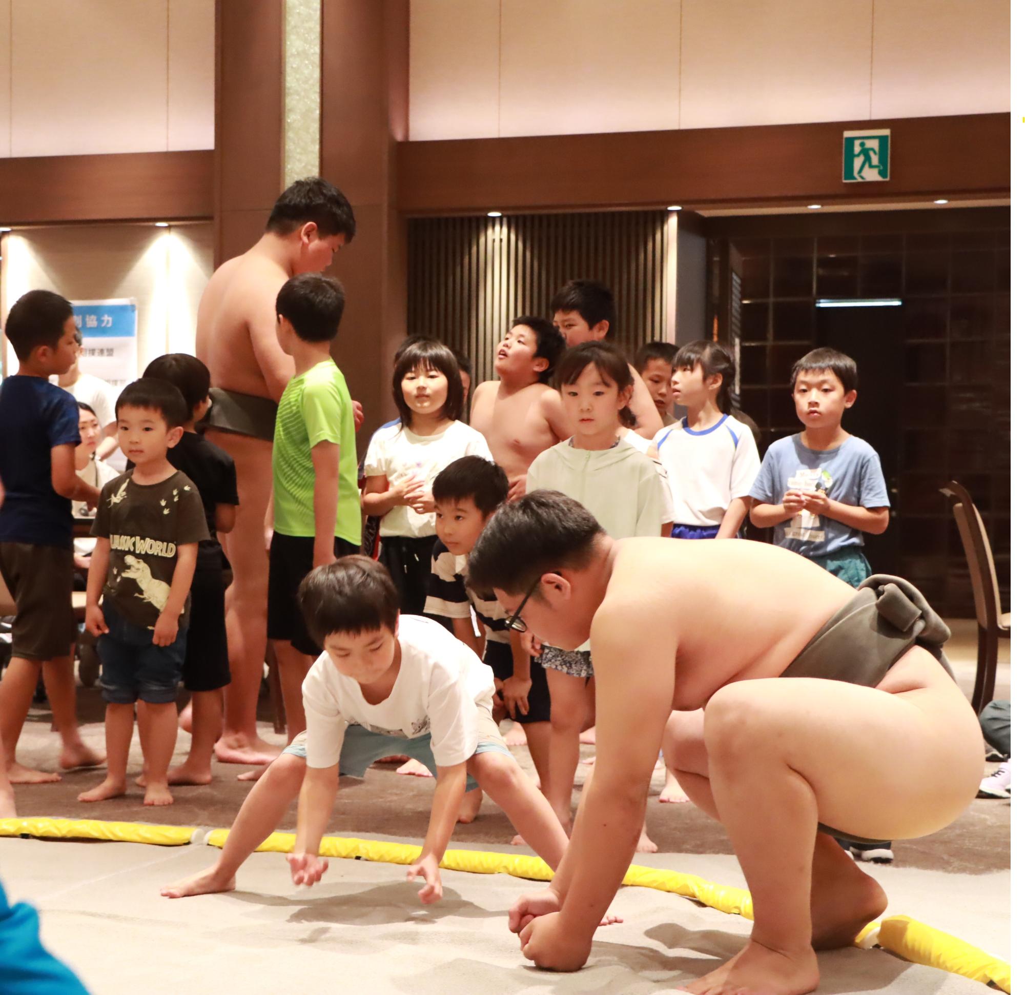 高校生相撲部から相撲を教わるこども