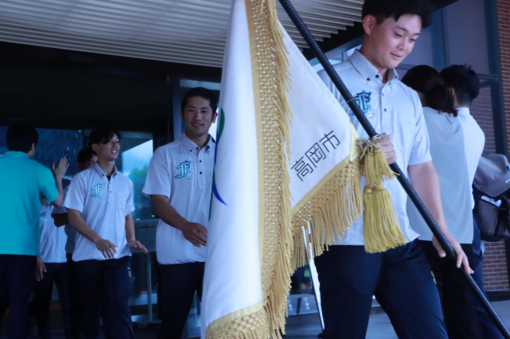 高岡市旗を持つ選手