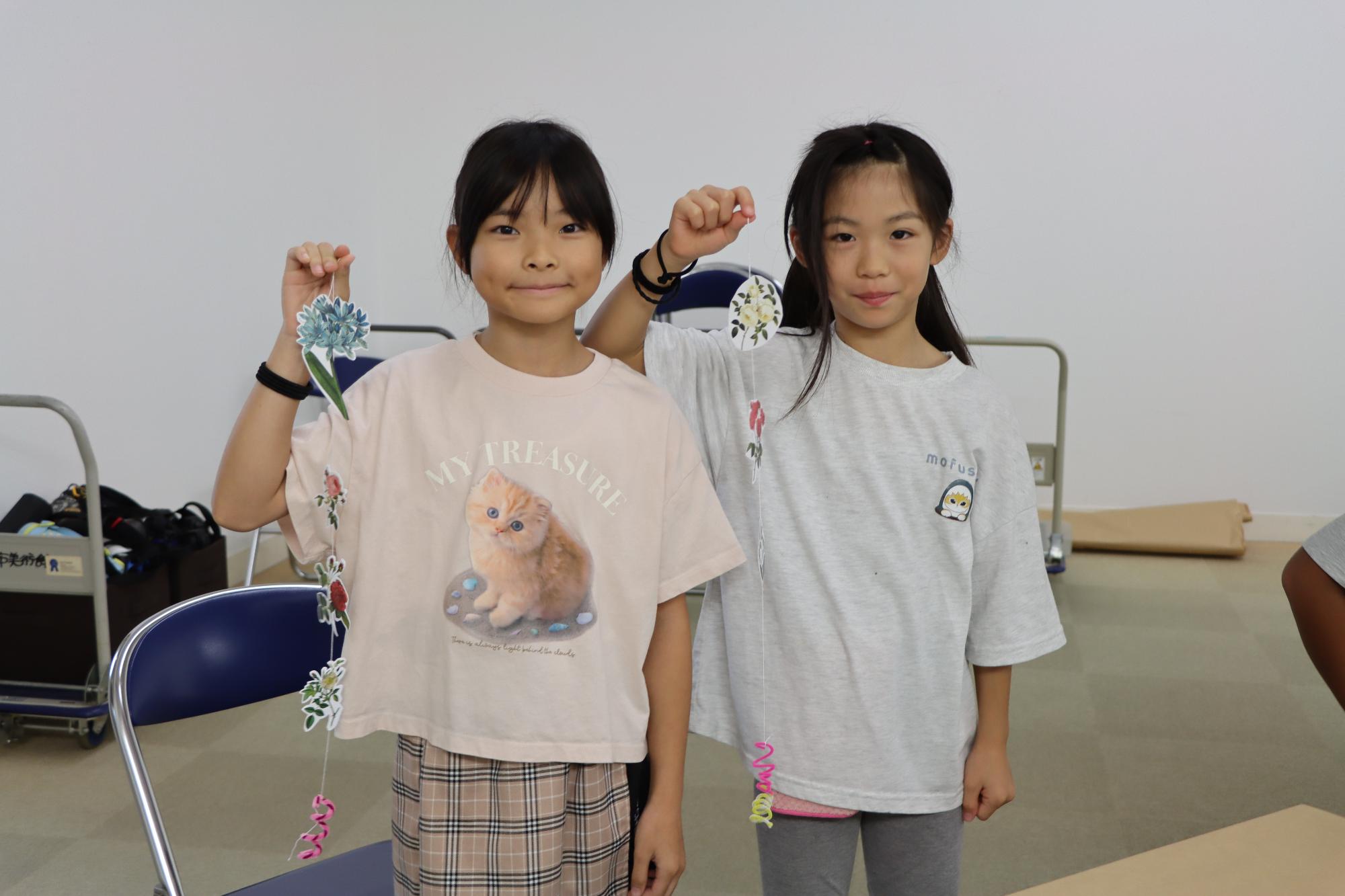 アート展で植物モチーフのモビールを作った二人の子ども
