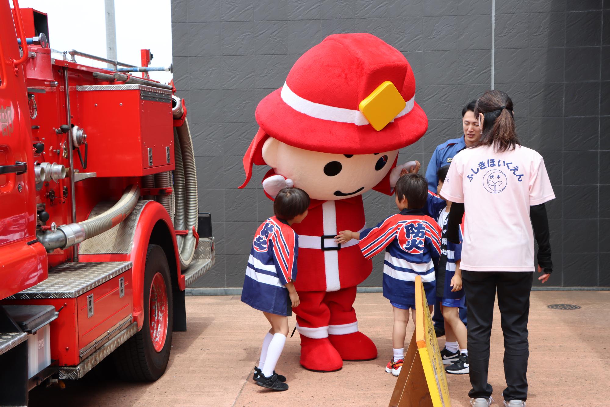 火の用心マスコットキャラクターに駆け寄るこどもたちの様子