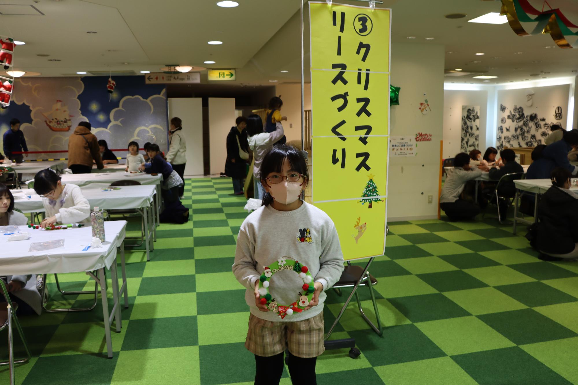 作ったクリスマスリースを披露してくれる子どもの様子