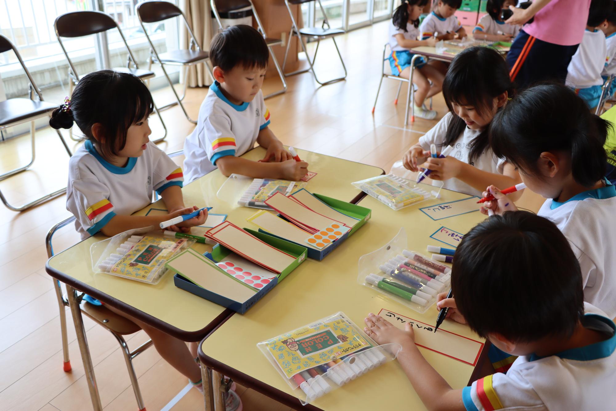 竹紙の短冊に願い事を書く園児たちの様子
