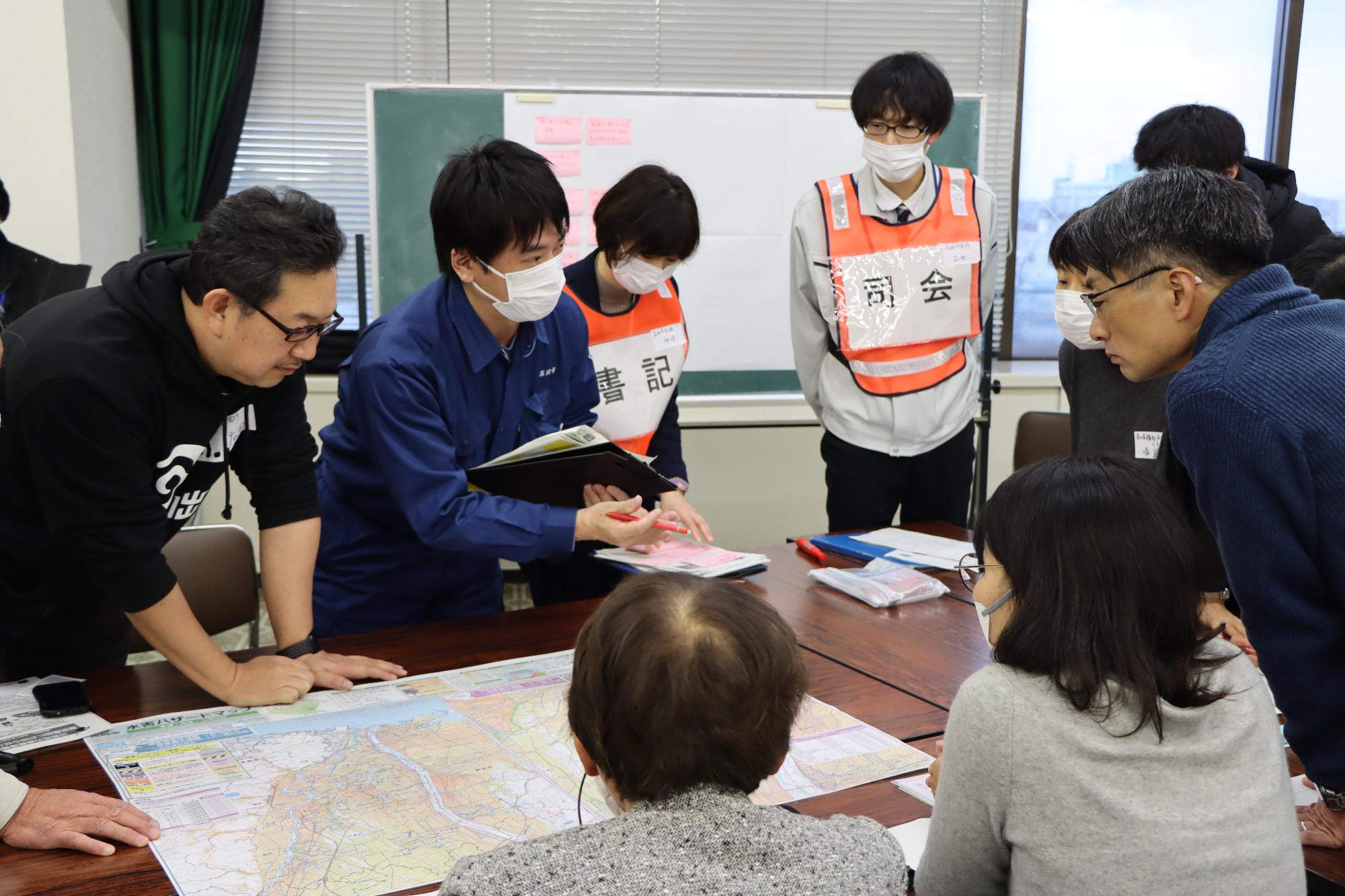 市の職員と自治会長や民生委員などが避難計画を話し合う様子