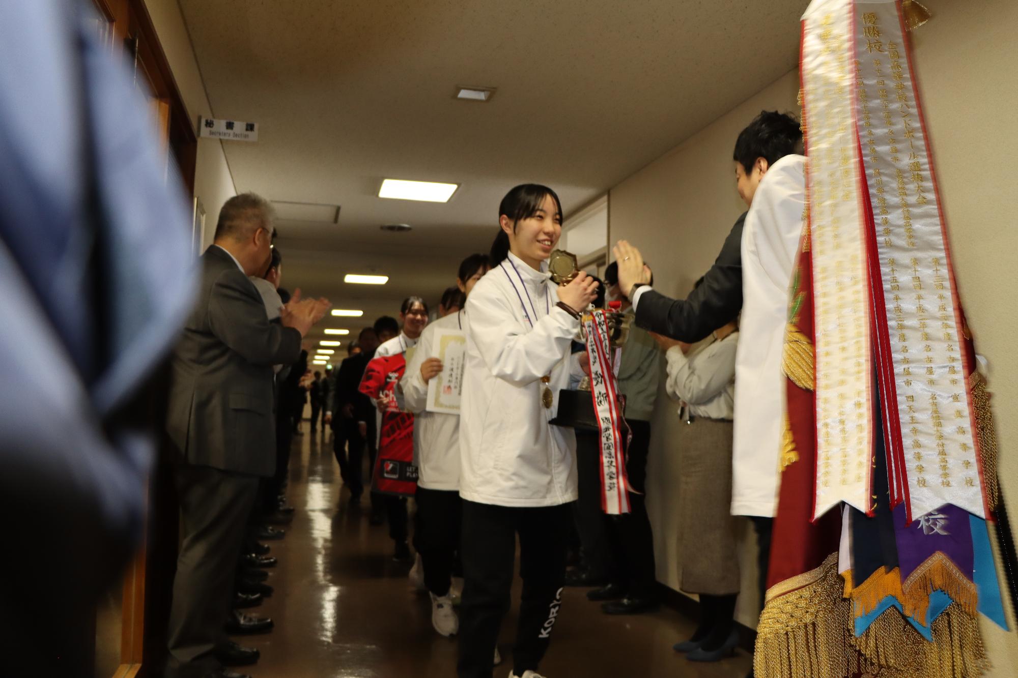 多くの市職員が高岡高陵高校女子ハンドボール部員の皆さんを出迎えている様子