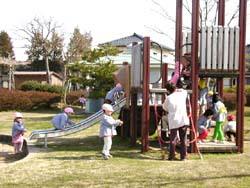 滑り台付きアスレチック型の遊具で遊ぶ子供達の写真
