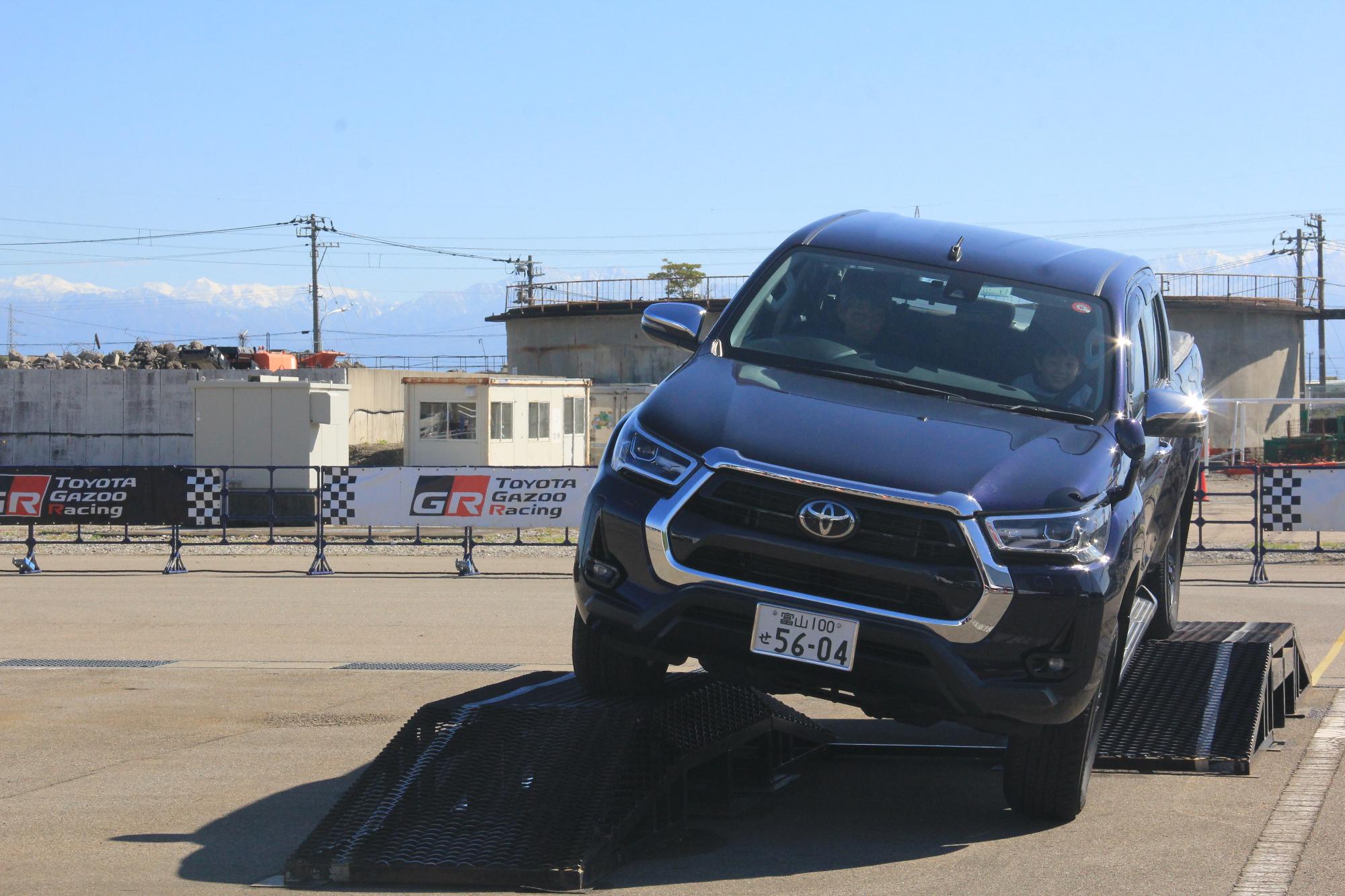 屋外に仮設されたを障害物を乗り越える黒い車