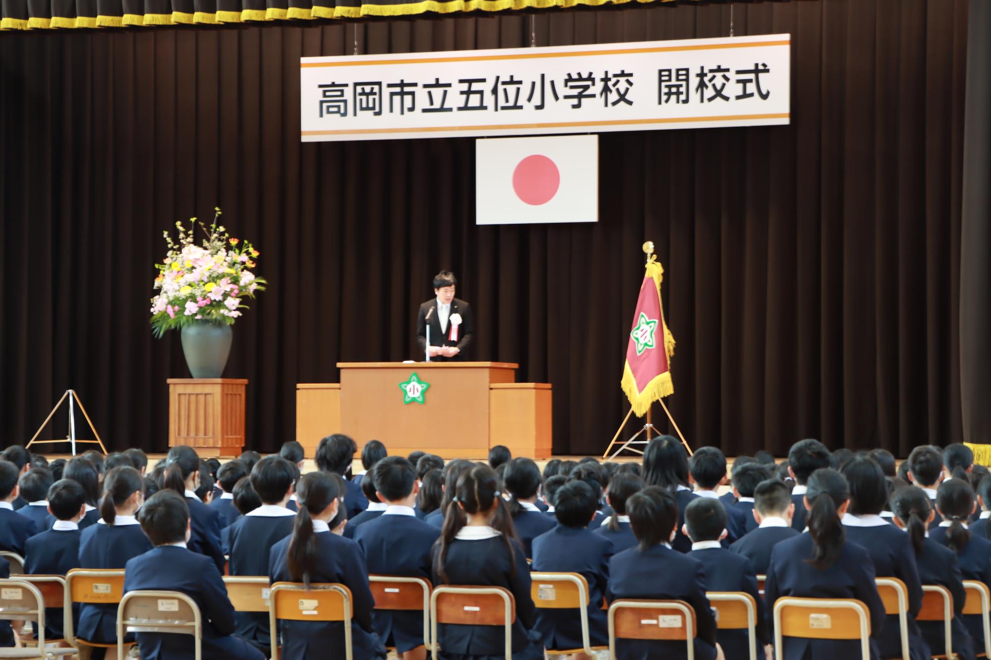 五位小学校の開校式にて多くの生徒の前で祝辞を述べる市長