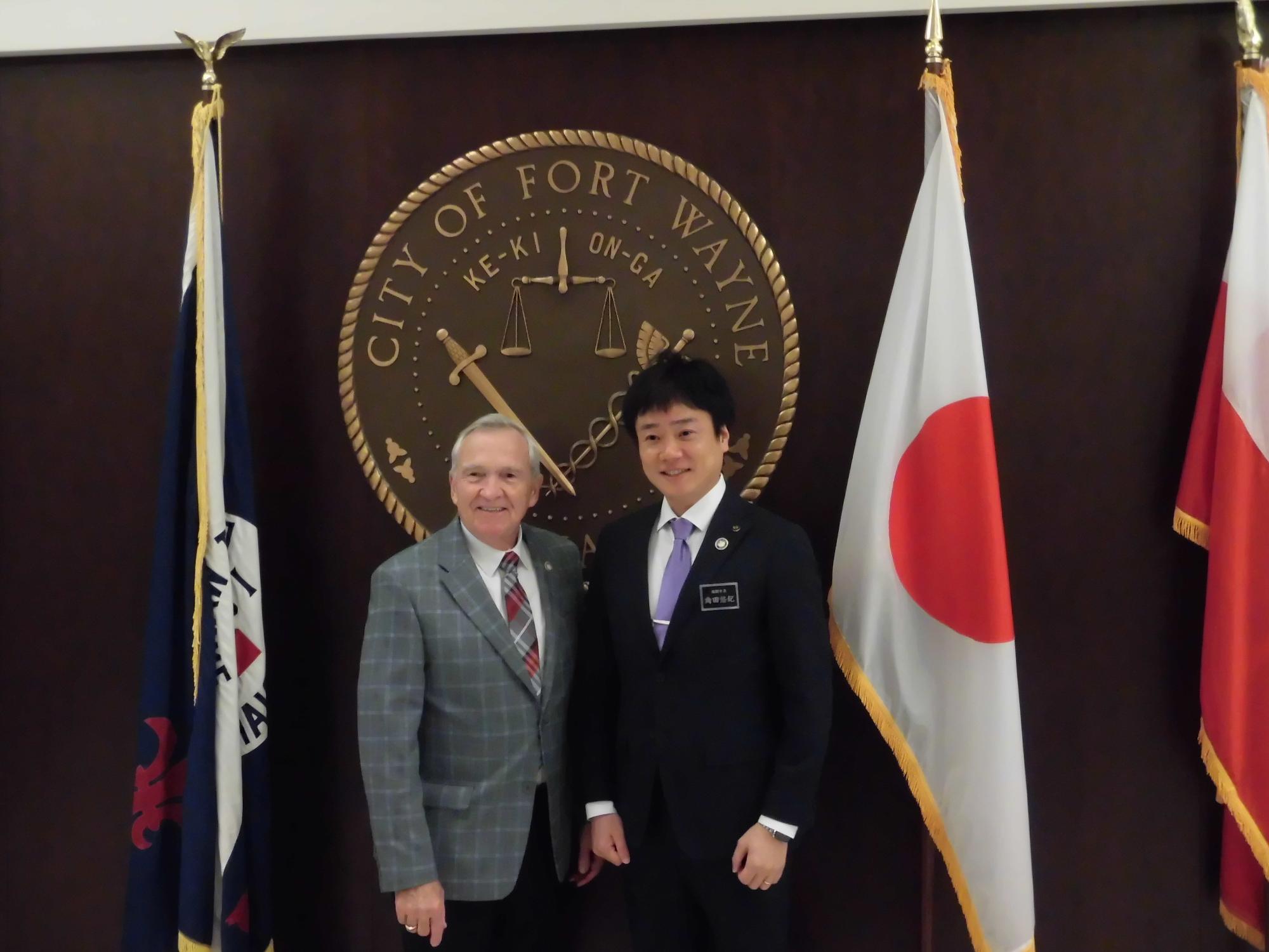 高岡市の姉妹都市であるアメリカ合衆国フォートウェーン市のヘンリー市長とともに笑顔で映る角田市長